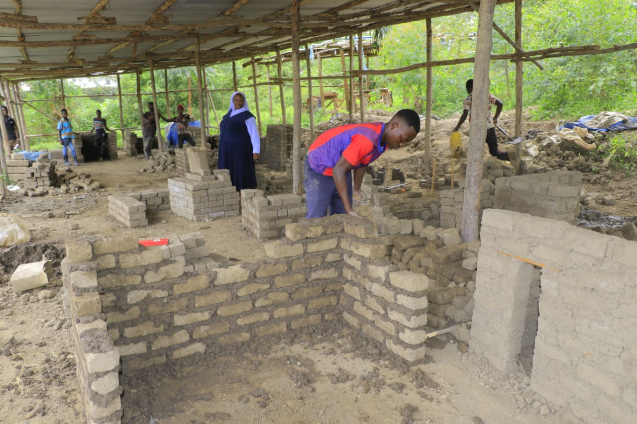 Learners constructing brick walls during a building class