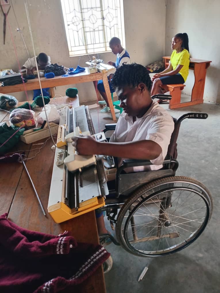 A learner using a knitting machine during practical training